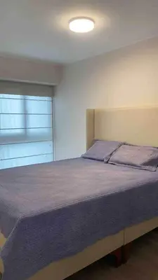 a bedroom with a large bed with a window at SWEET HOME MIRAFLORES in Lima
