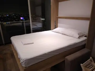 a bed in a room with a view of a city at Barranco landscape suite boardwalk in Lima
