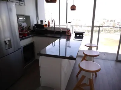 a kitchen with a counter and two bar stools at Barranco landscape suite boardwalk in Lima