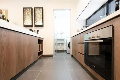 a kitchen with a black oven and wooden cabinets at Stunning Modern 1BD Apartment in Barranco in Lima