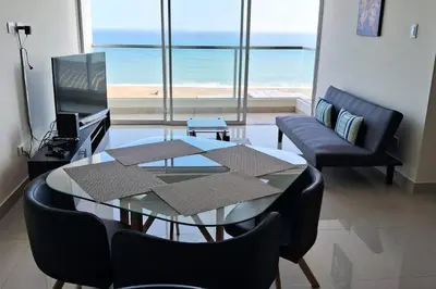 a living room with a glass table and chairs at apartamento de estreno con balcón frente al mar. in Lima
