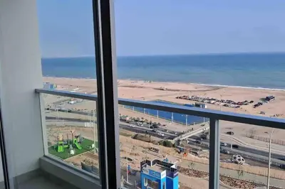 a view of the beach from a room with a window at apartamento de estreno con balcón frente al mar. in Lima