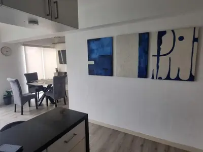 a living room with a dining table and paintings on the wall at Big Apartment 2 rooms next to Miraflores in Lima