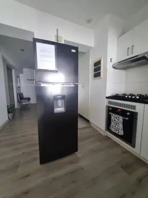 a black refrigerator in a kitchen with a stove at Big Apartment 2 rooms next to Miraflores in Lima
