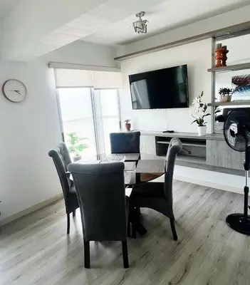 a dining room with a table and chairs and a television at Big Apartment 2 rooms next to Miraflores in Lima