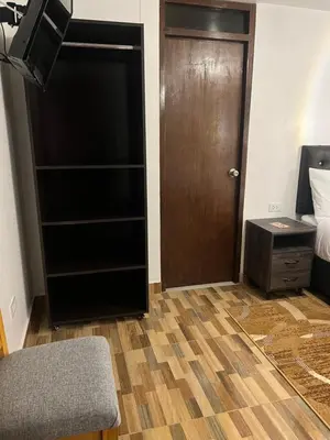 a room with a closet and a door and a bed at TAYWA HOTEL in Machu Picchu