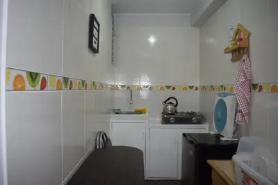 a kitchen with white walls and a table and a sink at El Valle - Lunahuaná in Lunahuaná