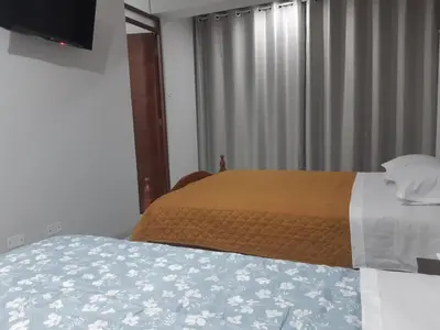 a bedroom with a bed and a window with a television at El Valle - Lunahuaná in Lunahuaná