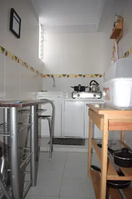 a small kitchen with white cabinets and a table at El Valle - Lunahuaná in Lunahuaná