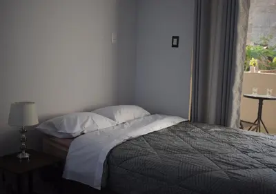 a bedroom with a bed with pillows and a window at El Valle - Lunahuaná in Lunahuaná