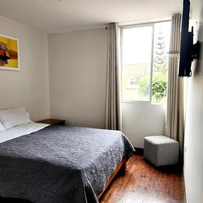 a small bedroom with a bed and a window at Casita Cultura in Lima