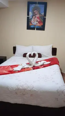 a bed with two white towels in the shape of a heart at Gia's apartments in Cusco