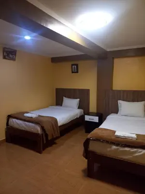 a hotel room with two beds and a light on the ceiling at Gia's apartments in Cusco
