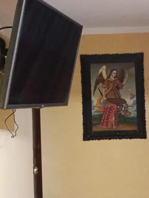a picture of a painting on a wall next to a lamp at Gia's apartments in Cusco
