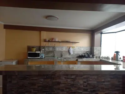 a kitchen with a stone counter top with a sink at Gia's apartments in Cusco