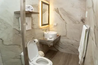 a bathroom with a white toilet and a sink at Hotel Curasi in Ica