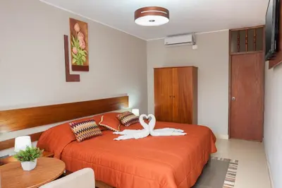 a bedroom with a bed with a swan on it at Hotel Curasi in Ica