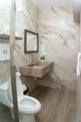 a bathroom with a white toilet and a sink at Hotel Curasi in Ica