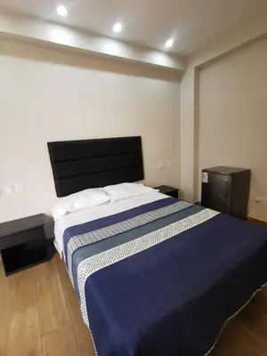 a bedroom with a large bed with a blue blanket at Hotel Sol de Marcona in San Juan de Marcona