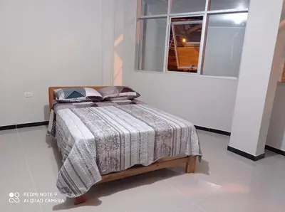 a bed in a white room with a window at Casa Alojamiento Virreynal in San Ramón