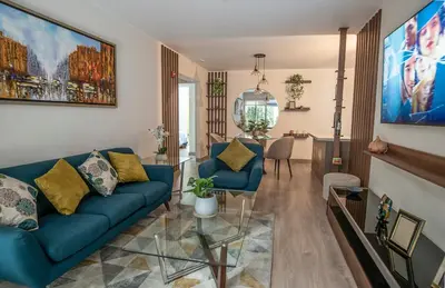 a living room with a blue couch and a table at Silvia's New Spacious Patio Pad in Lima