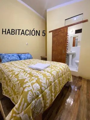 a bedroom with a bed with a bathroom sign at CASA ALVAREZ in Cusco
