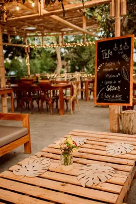 a wooden table with a vase of flowers on it at Hotel Fundo El Arrabal in Ica