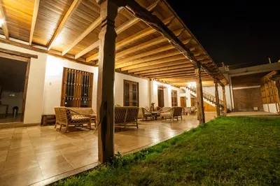 a wooden pergola with chairs and tables on a patio at Hotel El Huarango in Ica