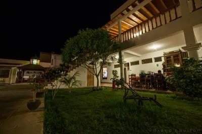 a house with a yard with a table and chairs at Hotel El Huarango in Ica