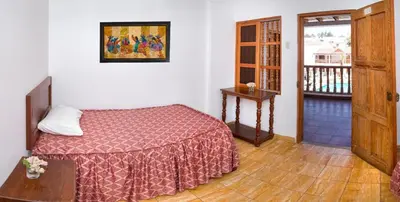 a bedroom with a bed and a wooden floor at Hotel El Huarango in Ica