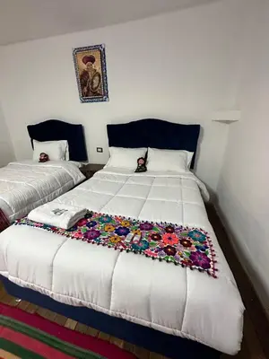 a bedroom with two beds with a blanket on it at AITANA'S HOUSE - SAN BLAs in Cusco