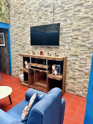 a living room with a tv on a brick wall at AITANA'S HOUSE - SAN BLAs in Cusco