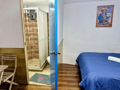 a bedroom with a blue bed and a bathroom at AITANA'S HOUSE - SAN BLAs in Cusco