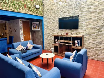 a living room with blue couches and a tv at AITANA'S HOUSE - SAN BLAs in Cusco