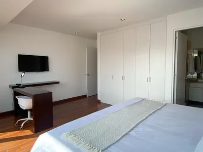 a bedroom with a bed and a desk and a tv at Modern Penthouse & 2BR in Miraflores by Wynwood House in Lima