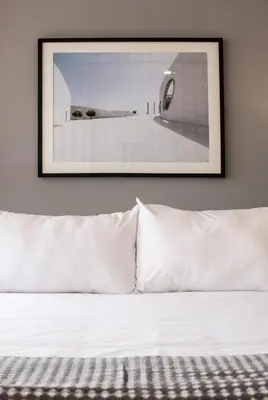 a picture hanging above a bed with white pillows at Modern Penthouse & 2BR in Miraflores by Wynwood House in Lima