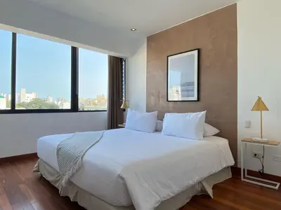 a bedroom with a large white bed with large windows at Modern Penthouse & 2BR in Miraflores by Wynwood House in Lima