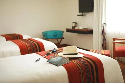 a hotel room with two beds with a hat on the bed at San Agustin Plaza in Cusco