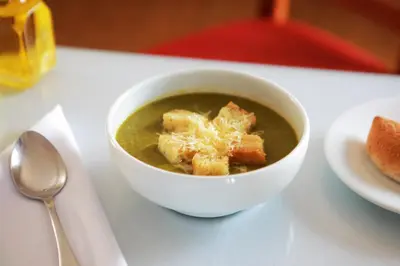 a bowl of soup on a table with a spoon at San Agustin Plaza in Cusco
