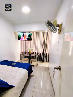 a bedroom with a bed and a table and a tv at Hospedaje Comfort Lima in Lima