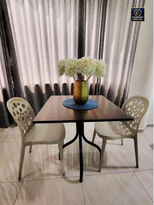 a table with a vase with white flowers on it at Hospedaje Comfort Lima in Lima