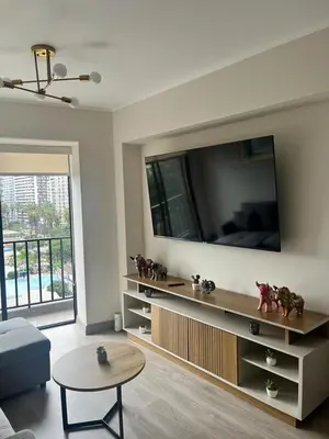a living room with a large tv on the wall at Departamento de Estreno en Barranco in Lima