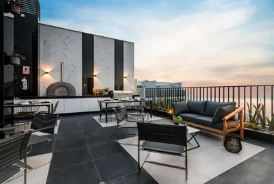 a rooftop patio with tables and chairs on a building at Departamento de Estreno en Barranco in Lima