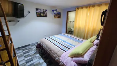 a small bedroom with a bed and a television at TRANSFER VIP HOSTEL in Lima
