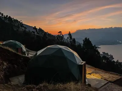 a tent on the side of a hill with a lake at Pacucha Glamping in Andahuaylas