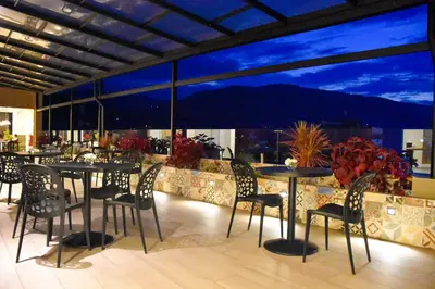 a restaurant with tables and chairs and a view of the mountain at Muña Hotel Andahuaylas in Andahuaylas