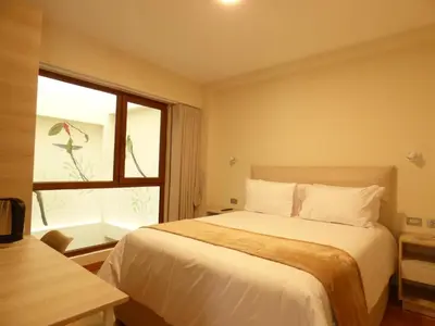 a bedroom with a large bed and a window at Muña Hotel Andahuaylas in Andahuaylas