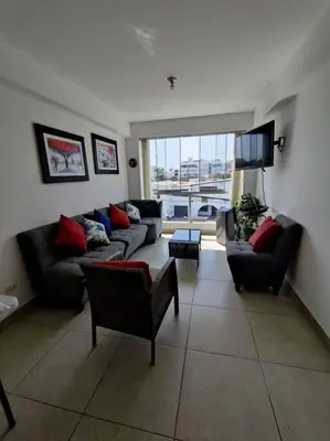 a living room with two couches and a tv at Excelente departamento frente al mar. in San Bartolo