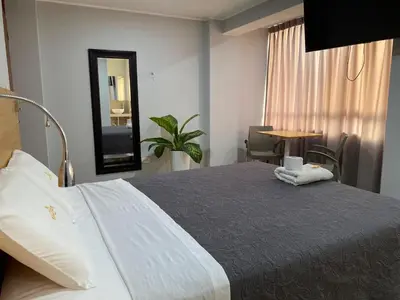 a bedroom with a bed with a mirror and a table at Millennium Hotel Corporative in San Vicente de Cañete