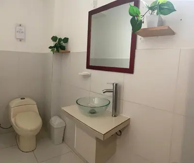 a bathroom with a sink and a toilet and a mirror at Millennium Hotel Corporative in San Vicente de Cañete